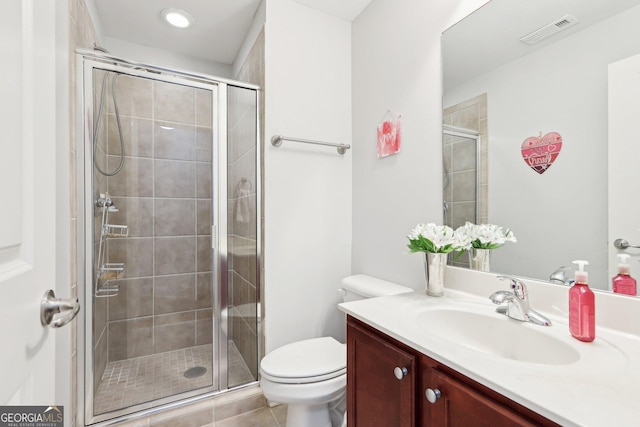 bathroom featuring an enclosed shower, vanity, tile patterned floors, and toilet