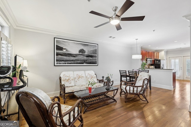 living room featuring ceiling fan, ornamental molding, and dark hardwood / wood-style flooring