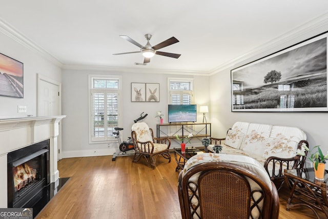 sitting room featuring ornamental molding, wood-type flooring, and ceiling fan