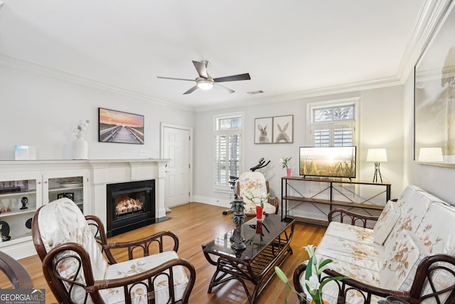 living room featuring crown molding, ceiling fan, and light wood-type flooring