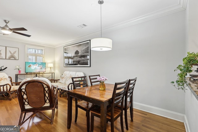 dining room featuring hardwood / wood-style flooring, ornamental molding, and ceiling fan