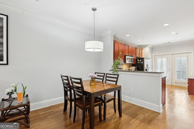 dining room featuring hardwood / wood-style flooring and crown molding