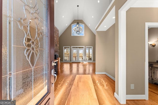 foyer featuring a notable chandelier, hardwood / wood-style flooring, high vaulted ceiling, and french doors