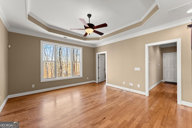 unfurnished room with ornamental molding, light hardwood / wood-style flooring, ceiling fan, and a tray ceiling