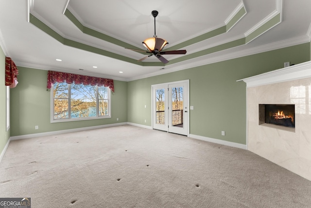 unfurnished living room featuring light carpet, a tray ceiling, and ornamental molding