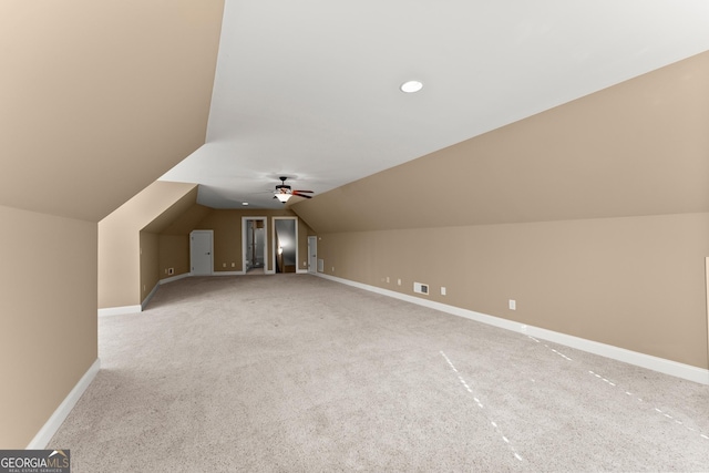 bonus room with lofted ceiling and light colored carpet