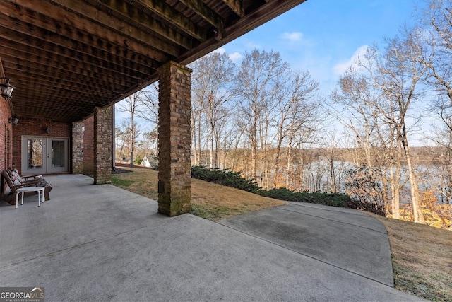 view of patio featuring a water view and french doors