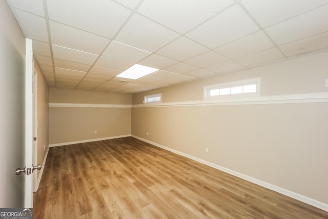 basement with hardwood / wood-style flooring and a paneled ceiling