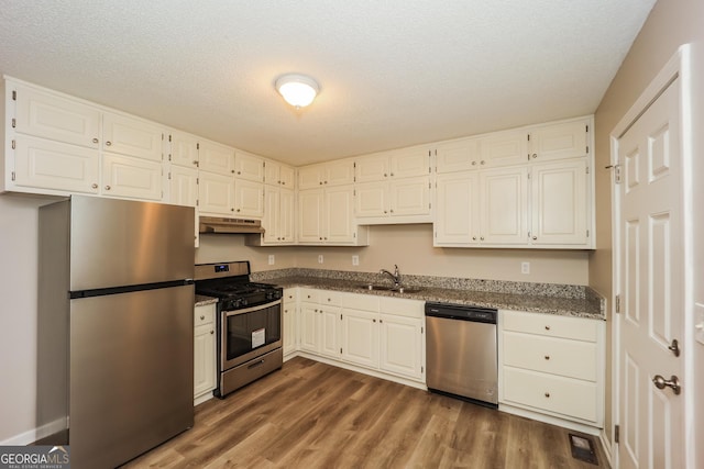 kitchen with white cabinetry, appliances with stainless steel finishes, sink, and wood-type flooring