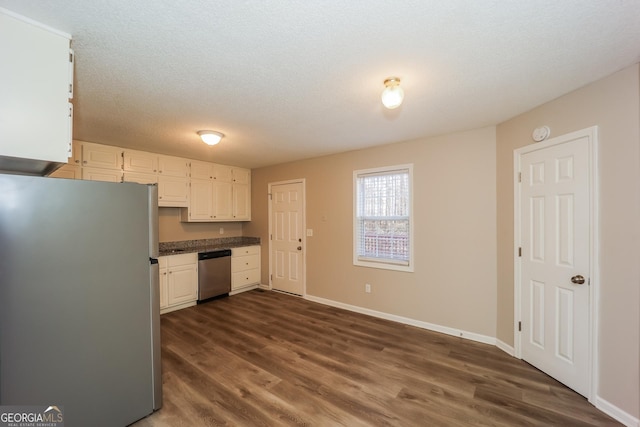 kitchen featuring stainless steel appliances, dark hardwood / wood-style floors, a textured ceiling, and white cabinets