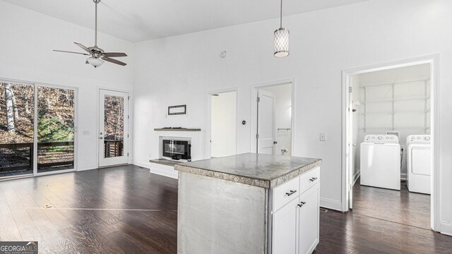 kitchen with stainless steel appliances, white cabinets, a kitchen island, dark hardwood / wood-style flooring, and decorative light fixtures