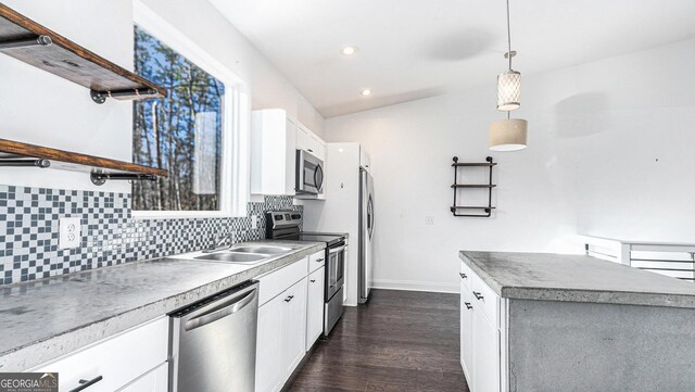 kitchen featuring decorative light fixtures, white cabinets, a high ceiling, dark wood-type flooring, and washer and clothes dryer