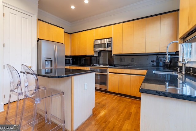 kitchen featuring sink, crown molding, stainless steel appliances, a kitchen island, and light wood-type flooring