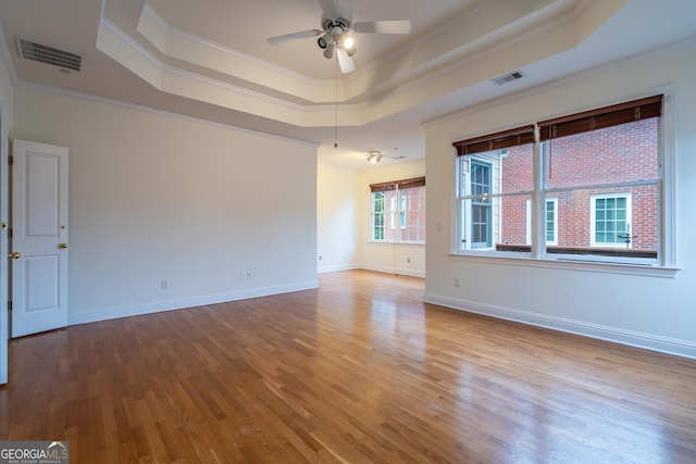 unfurnished room with crown molding, ceiling fan, a tray ceiling, and hardwood / wood-style floors