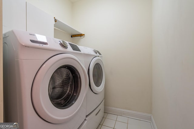 clothes washing area with light tile patterned floors and washing machine and clothes dryer