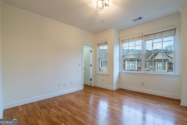 spare room with crown molding and wood-type flooring