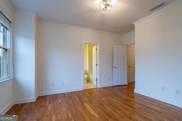 unfurnished bedroom with crown molding and hardwood / wood-style floors