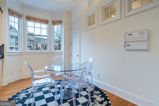 dining space with hardwood / wood-style floors and crown molding