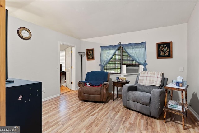 living area featuring cooling unit and light hardwood / wood-style flooring