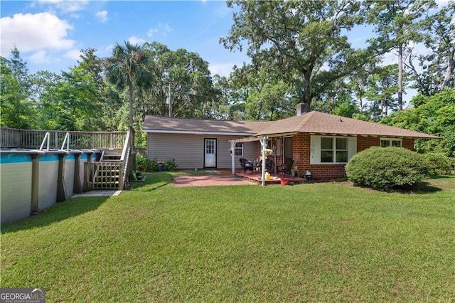 back of house featuring a patio and a lawn