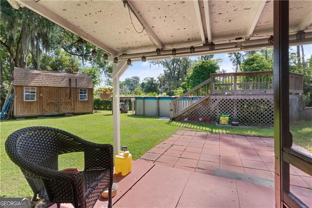 view of patio / terrace with a pool side deck and a storage unit