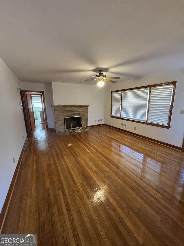 unfurnished living room featuring dark hardwood / wood-style floors and ceiling fan