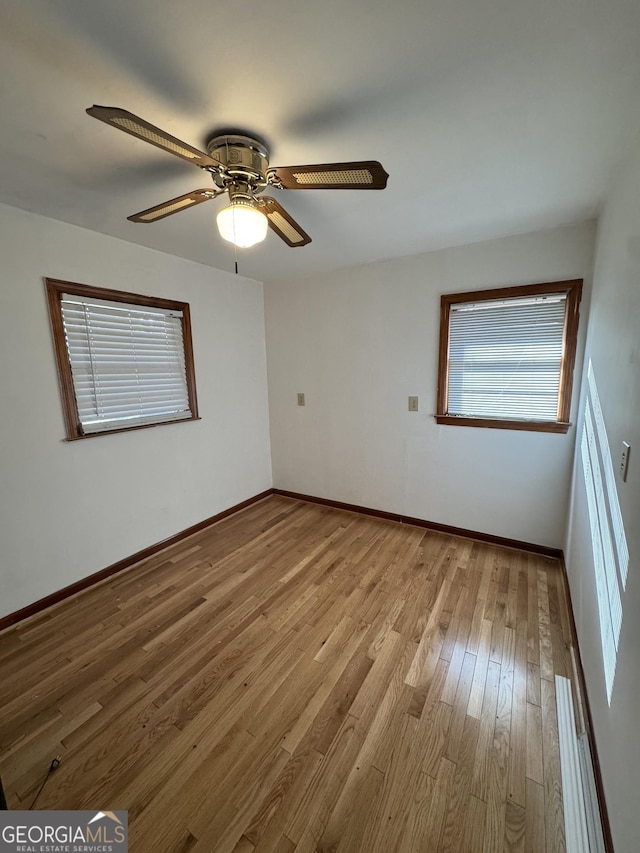 unfurnished room featuring ceiling fan, a baseboard heating unit, and light hardwood / wood-style floors