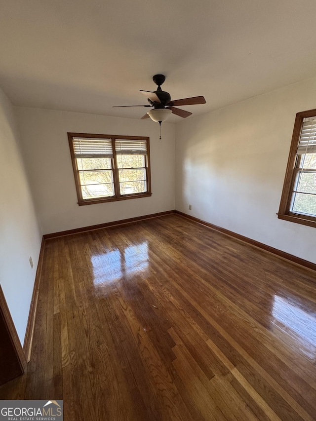 unfurnished room with dark wood-type flooring and ceiling fan