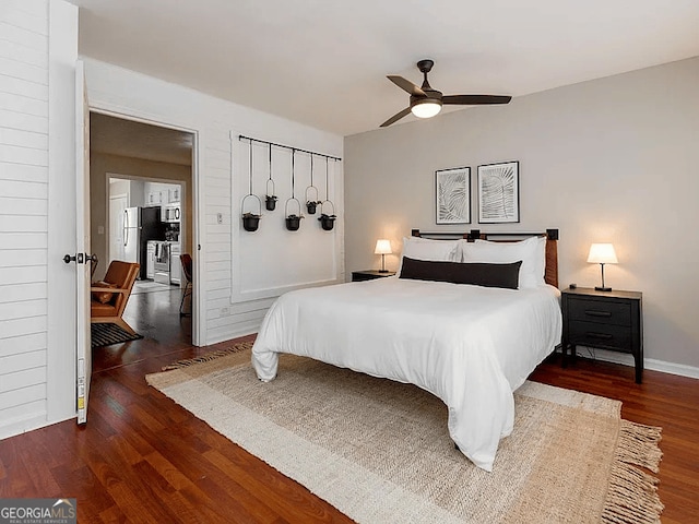 bedroom featuring stainless steel fridge, dark hardwood / wood-style floors, and ceiling fan