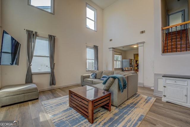 living room with hardwood / wood-style floors and ornate columns