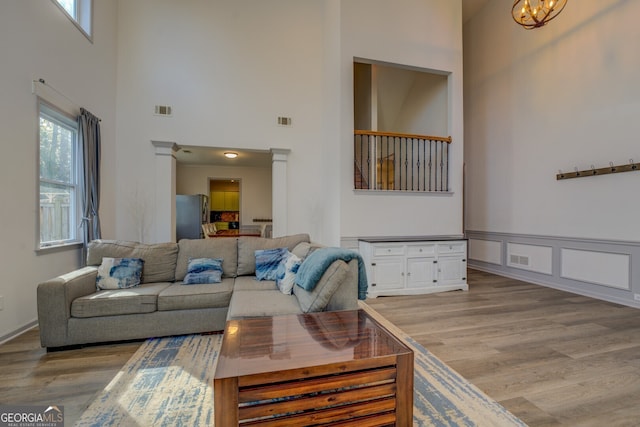 living room with a high ceiling, hardwood / wood-style floors, and a notable chandelier