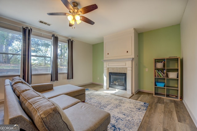 living room featuring hardwood / wood-style floors, a fireplace, and ceiling fan