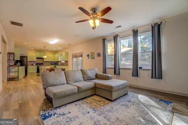 living room featuring ceiling fan and light hardwood / wood-style flooring