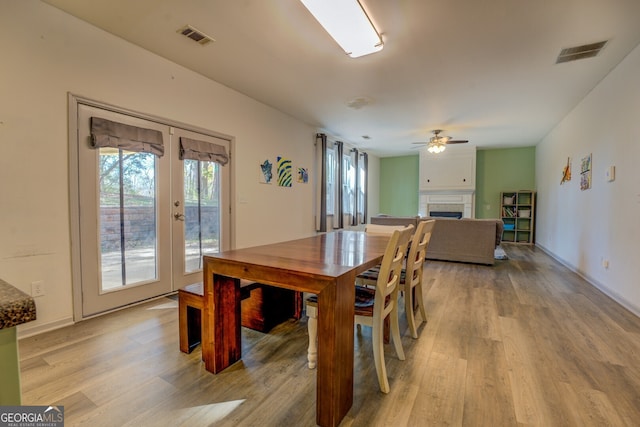 dining room featuring ceiling fan, light wood-type flooring, and french doors