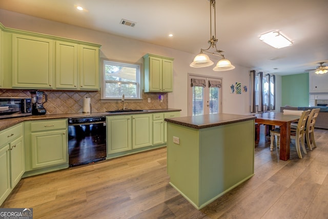 kitchen with french doors, green cabinetry, black dishwasher, and hanging light fixtures