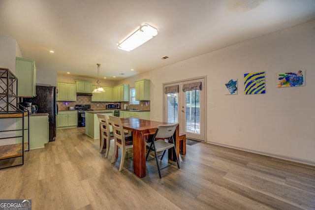 dining area with sink, light hardwood / wood-style floors, and french doors