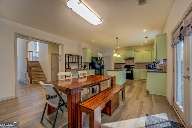 dining area with light hardwood / wood-style floors and sink