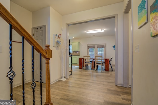 corridor featuring french doors and light wood-type flooring