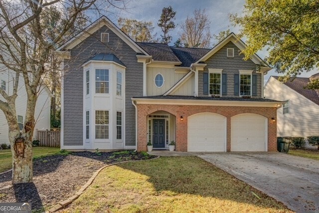 view of front of property featuring a garage and a front lawn