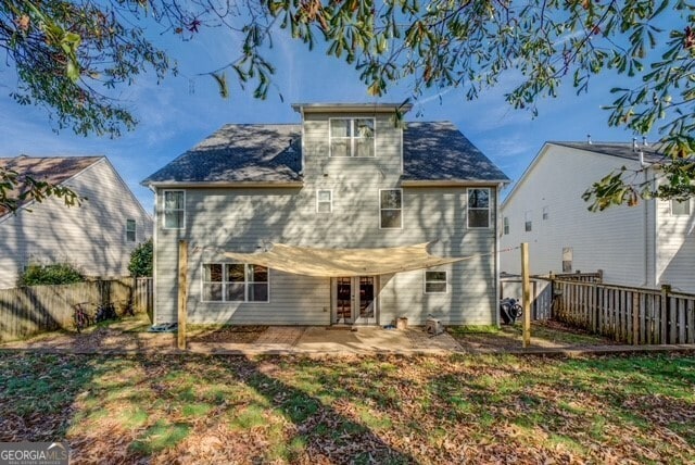 back of property with a patio area and a lawn