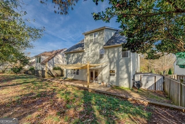 back of property with a patio and a shed