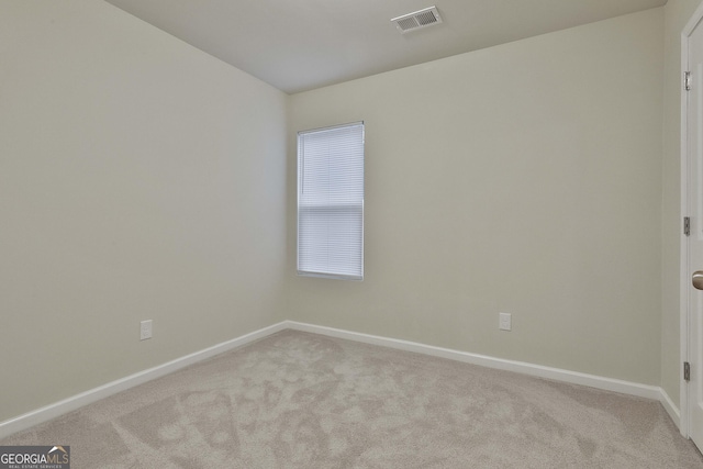 spare room featuring baseboards, visible vents, and carpet flooring