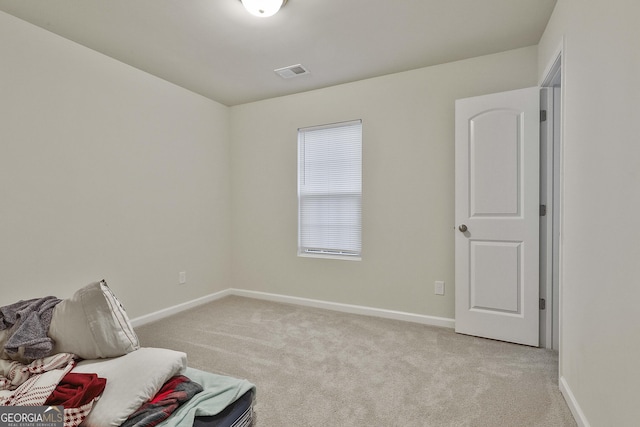 sitting room featuring baseboards, visible vents, and light colored carpet