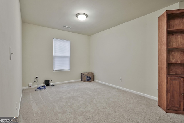 carpeted spare room featuring baseboards and visible vents