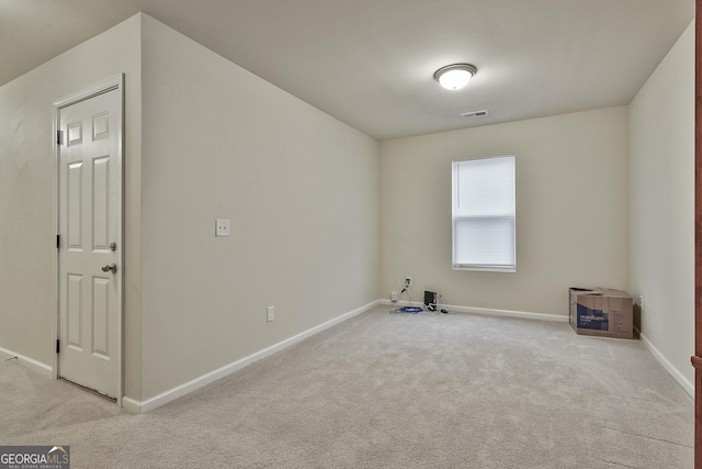 interior space with baseboards, visible vents, and light colored carpet