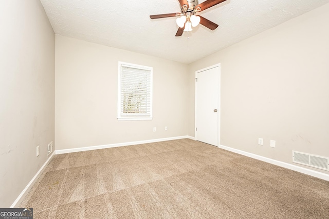 carpeted empty room featuring ceiling fan and a textured ceiling