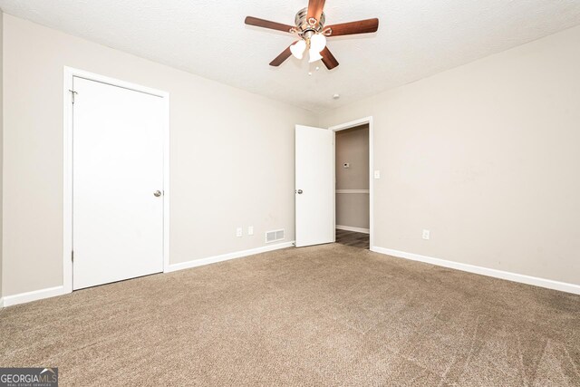 unfurnished room with ceiling fan, carpet flooring, and a textured ceiling