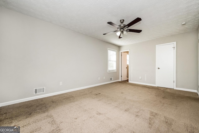 carpeted spare room with a textured ceiling and ceiling fan