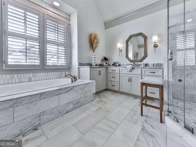 bathroom featuring vanity, plenty of natural light, lofted ceiling, and shower with separate bathtub