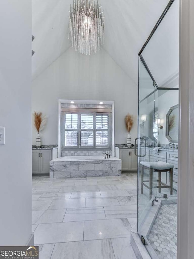 bathroom featuring vanity, high vaulted ceiling, a notable chandelier, and a bathtub